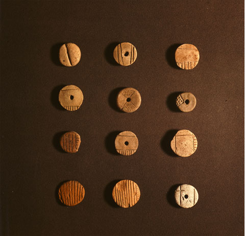 12 similarly shaped tokens with different markings