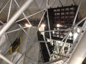 A picture of the 1st side VIRUS Spectrograph Enclosure being installed on the HET.  In the picture the team is busy installing the last section, the Top Annex.