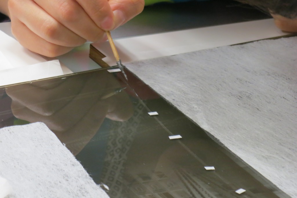 Application of the adhesive to the glass plate.