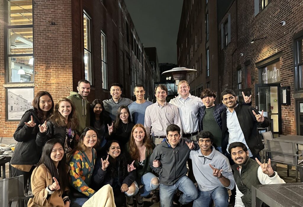 Large group photo on city street at AAPS 2022 in Boston - several students are giving hook 'em horns hand sign