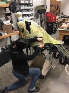 Student applying skin to raptor body
