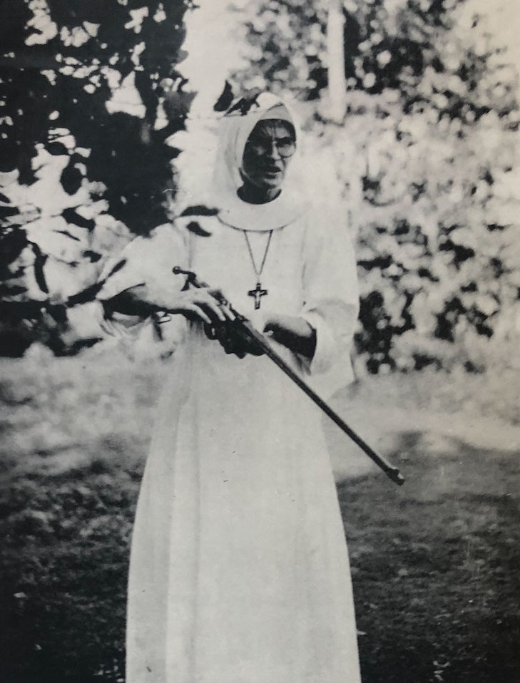 historical photo of a nun holding a rifle