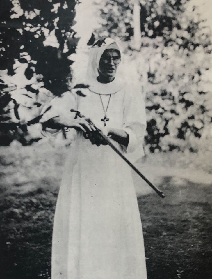 historic photo of nun holding a rifle