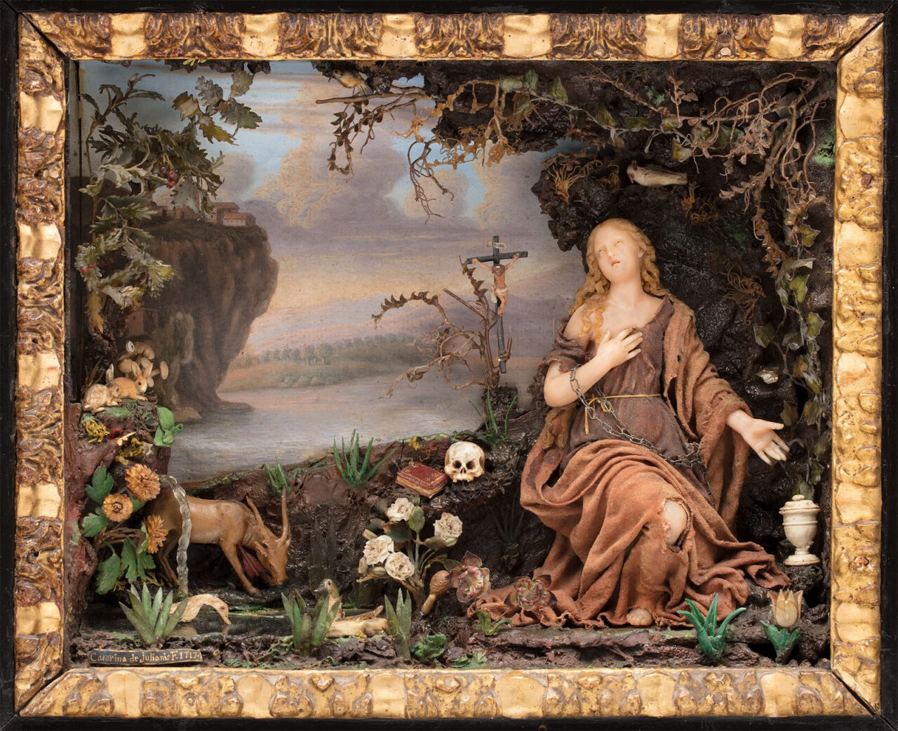 Historic female figure in robes surrounded by objects and a reference to Christ