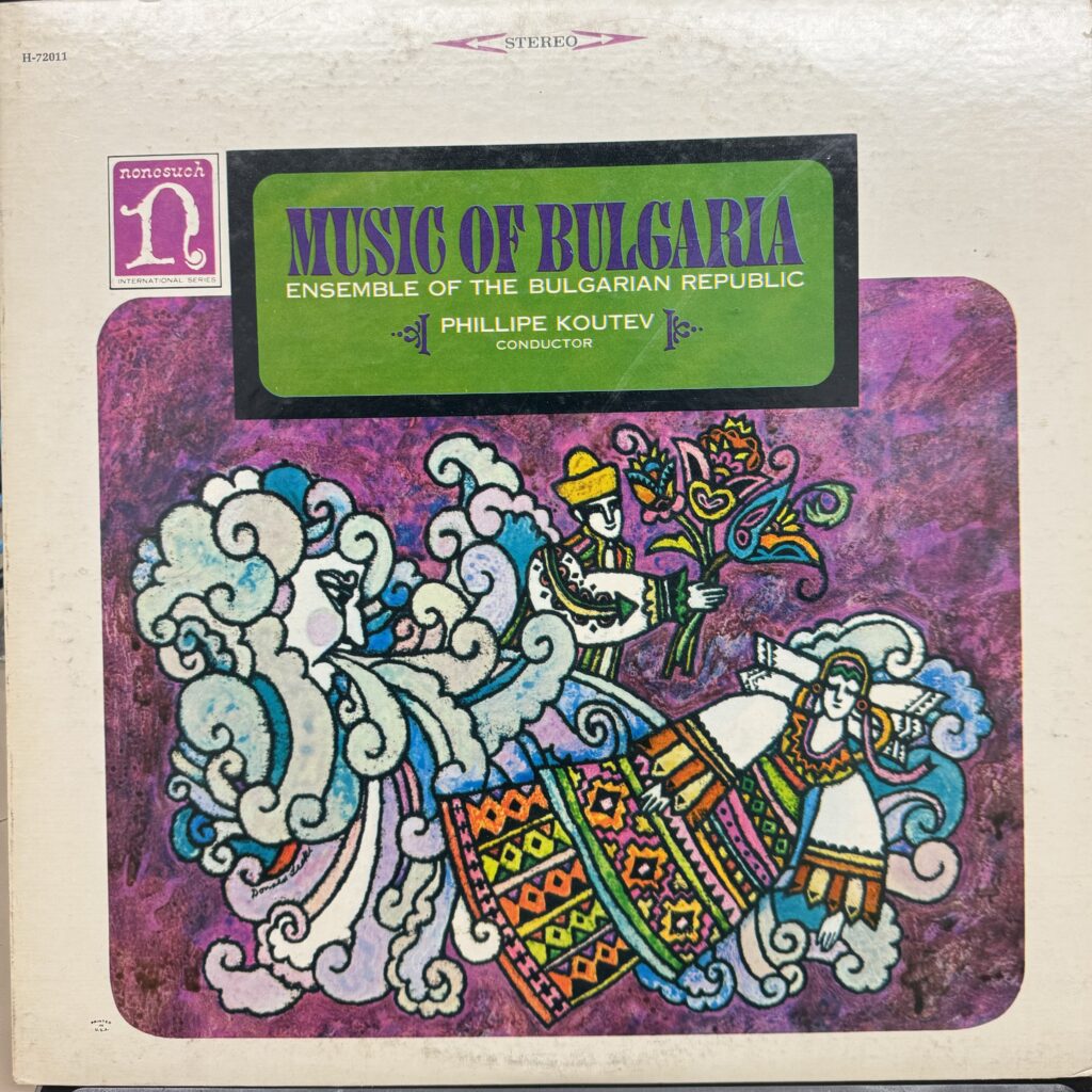 Photograph of the cover art of a vinyl disc of the music of Bulgaria, with a man giving flowers to a woman