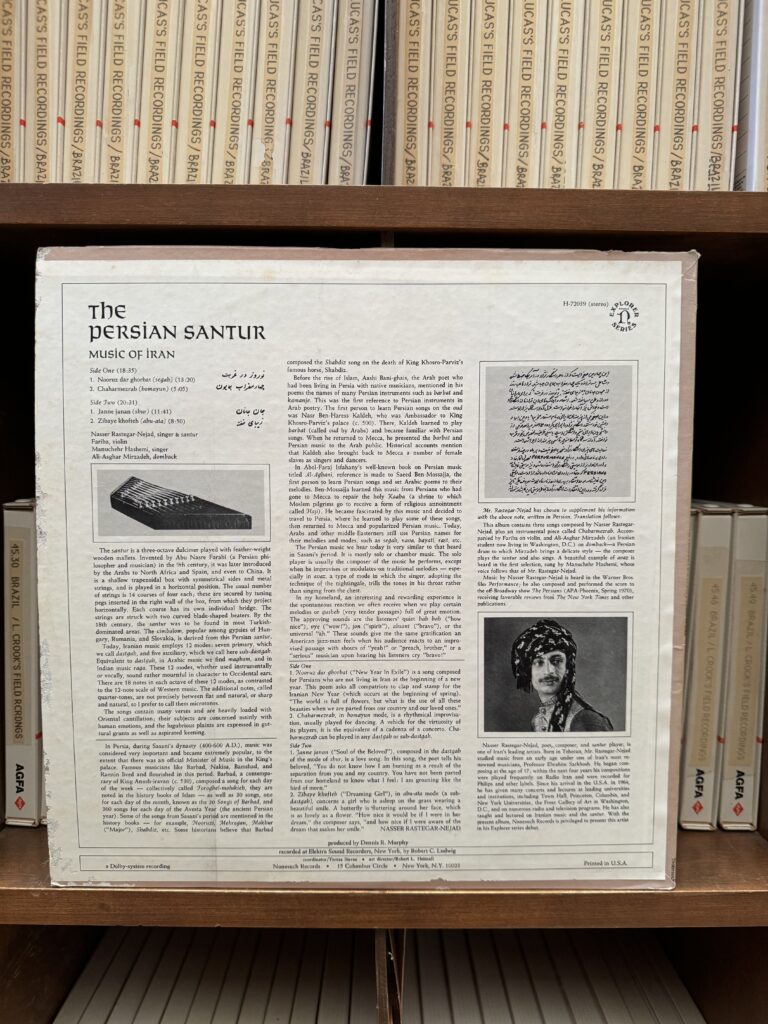 The photo of the back cover of the vinyl “The Persian Santoor”, with the photo of the instrument, Persian Santoor, the artist Nasser Rastegar-Nejad, and descriptions about the Vinyl and tapes in the background.