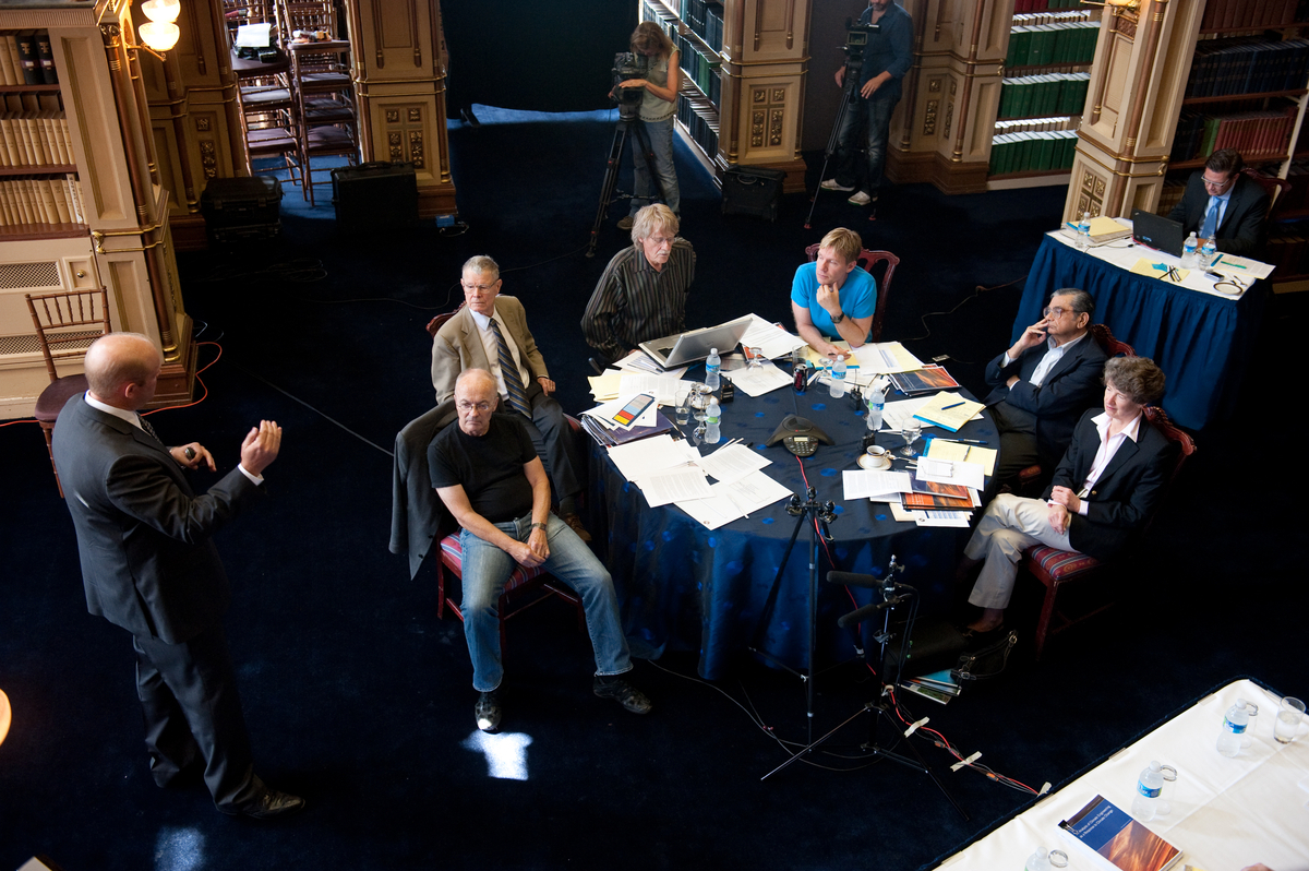 group sitting at table while Eric Bickel stands and presents