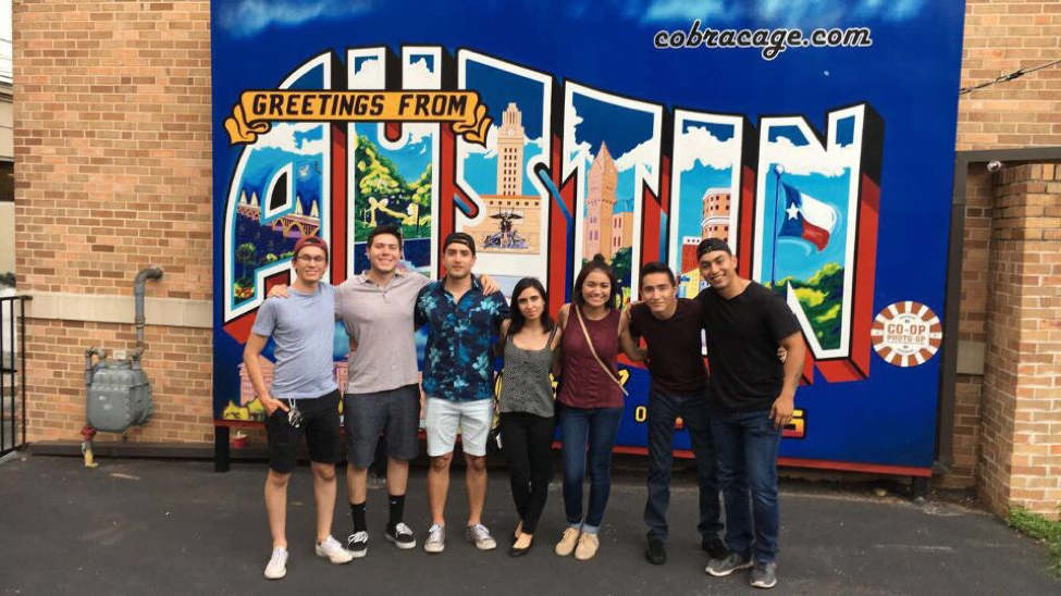 students standing in front of Austin wall mural
