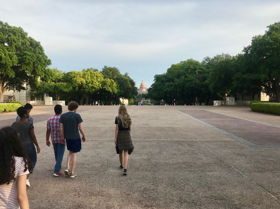 students walking on ut campus with capitol building in background
