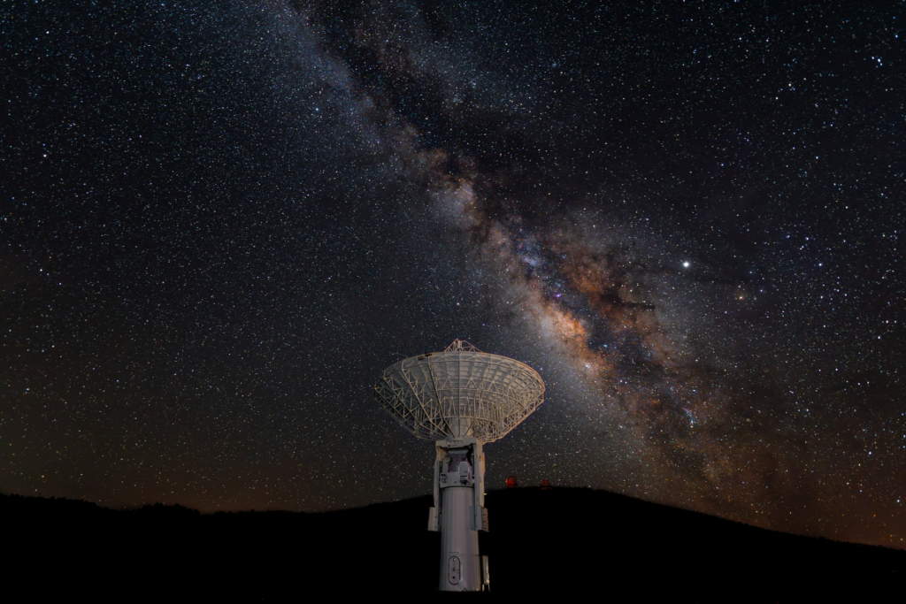 Radio Dish at McDonald Observatory in foreground with Milky Way in background.