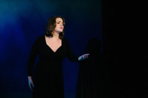 A woman in a black dress sings