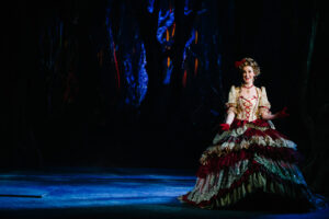 Cinderella stands on stage in her fancy, colorful dress