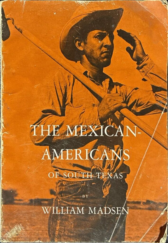 Book cover of The Mexican-Americans of South Texas, by William Madsen. The cover features a photograph of a man with a hat carrying long poles over his shoulder, with an orange background. The title and author's name appear in white.