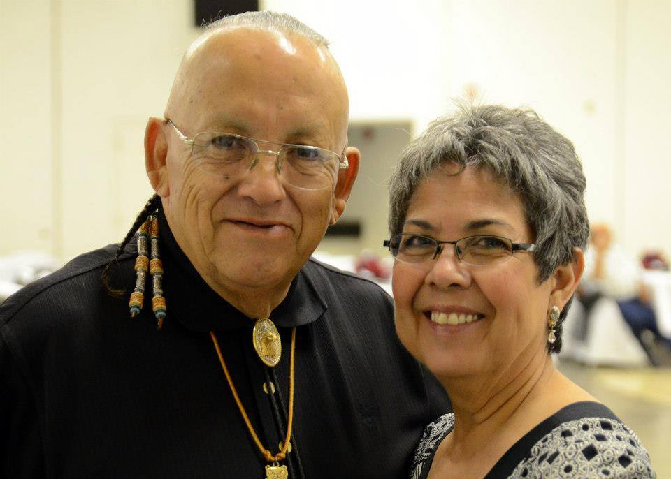 An elderly man and woman smiling at the camera.