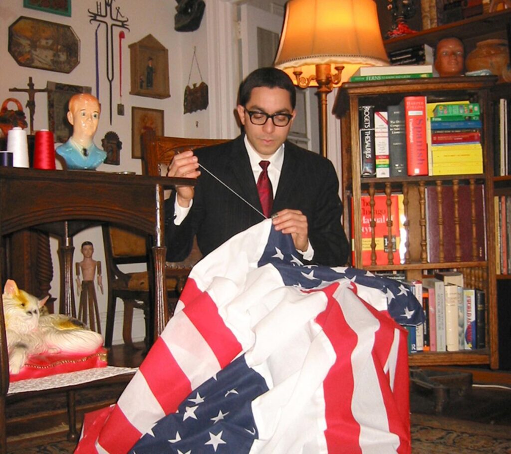 Photograph of the artist sewing a flag