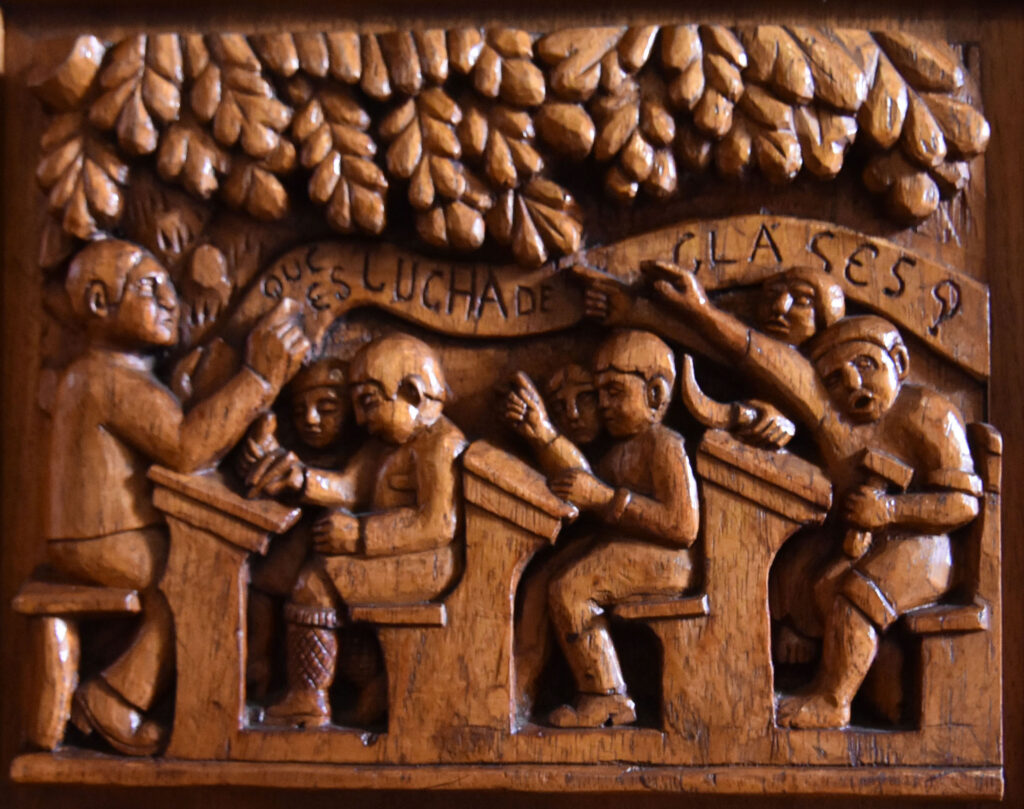 Detail from bench in Casa José Guadalupe Zuno library showing students and teacher in a classroom. Carved by Juan Hernández.