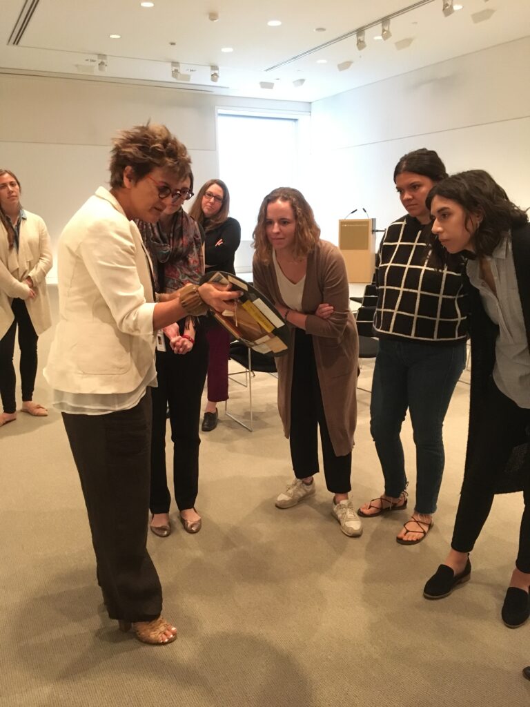 CLAVIS examine a work of Brazilian abstract art curator Mari Carmen Ramirez holds in her hand