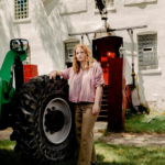 portrait of Abigail Winograd outdoors standing by a tractor