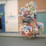 ambulant vendor in Mexico City carrying many balloons on a street
