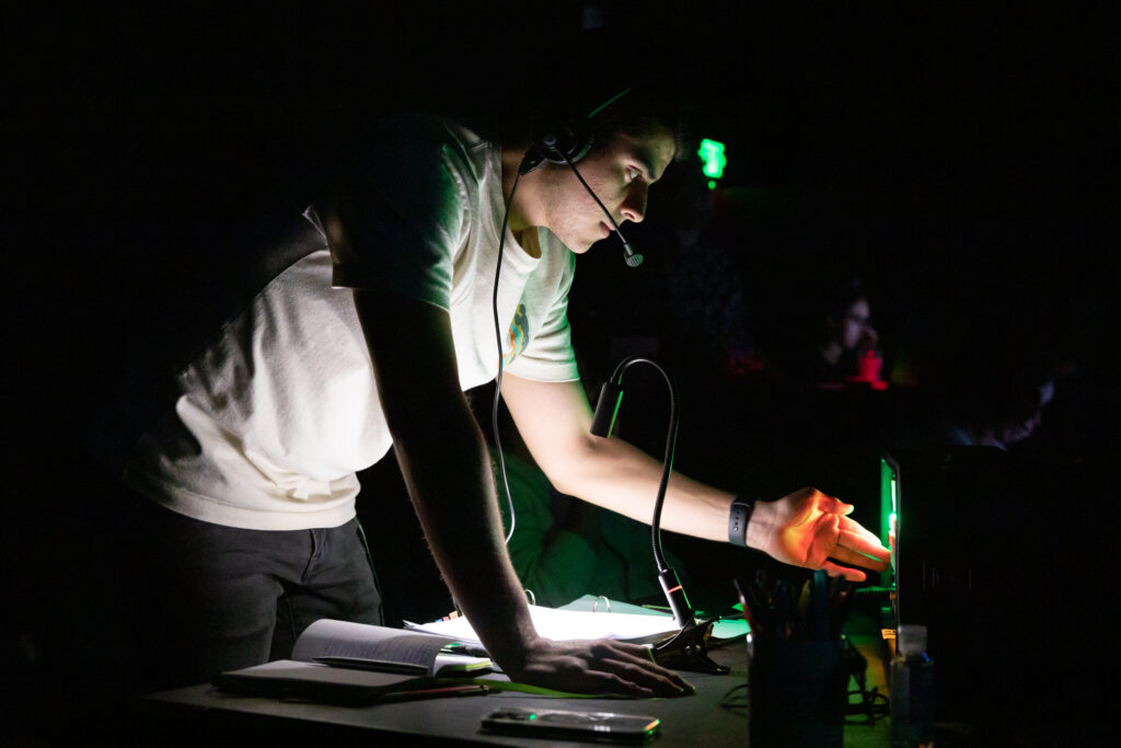 Student operating a sound board at a theatrical event