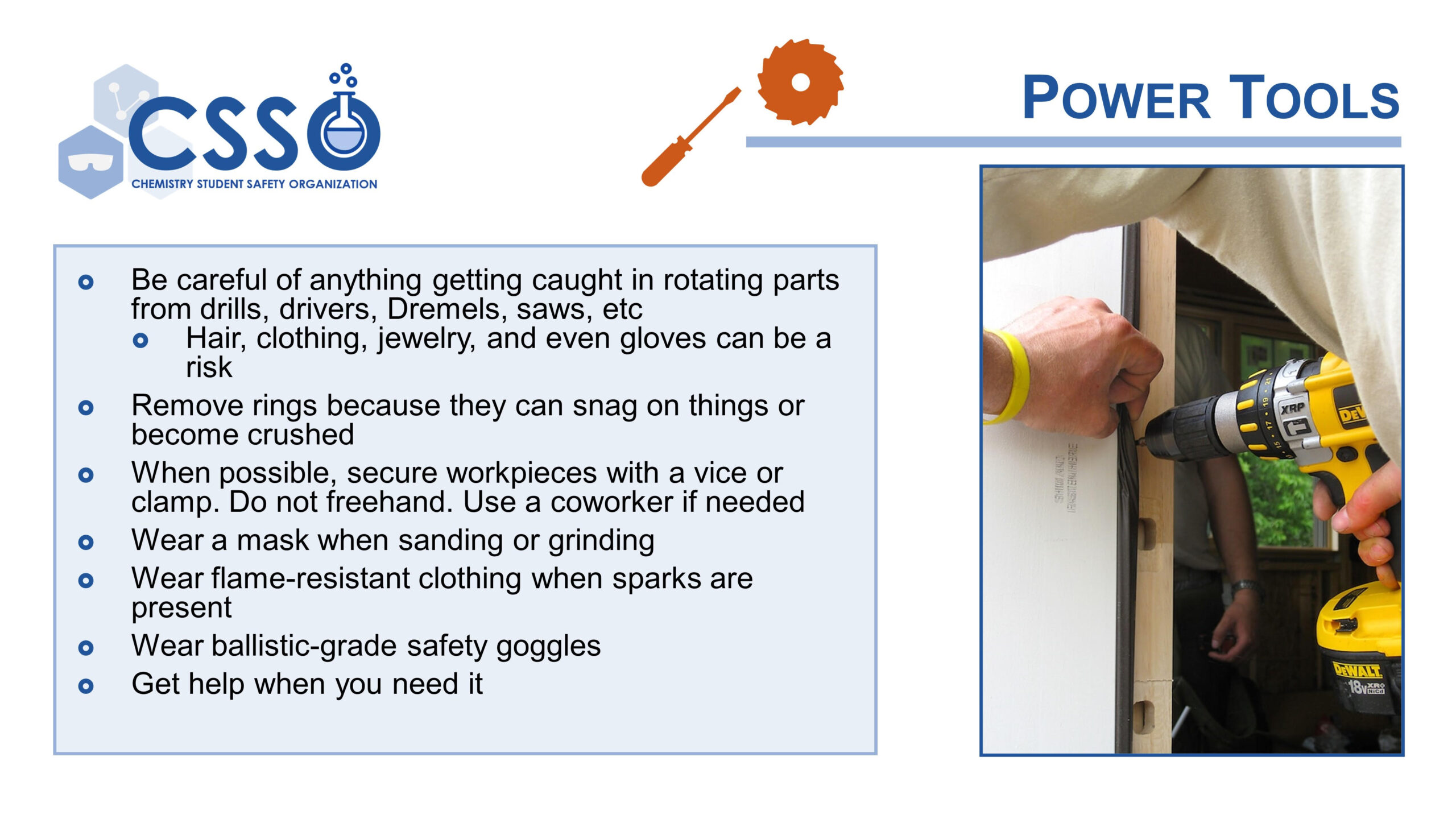 A slide with text and the CSSO logo in the top left corner, as well as a picture of a person drilling a door frame on the right side. The title is Power tools.. The text says "Be careful of anything getting caught in rotating parts from drills, drivers, Dremels, saws, etc. Hair, clothing, jewelry, and even gloves can be a risk. Remove rings because they can snag on things or become crushed. When possible, secure workpieces with a vice or clamp. Do not freehand. Use a coworker if needed. Wear a mask when sanding or grinding. Wear flame-resistant clothing when sparks are present. Wear ballistic-grade safety goggles. Get help when you need it.