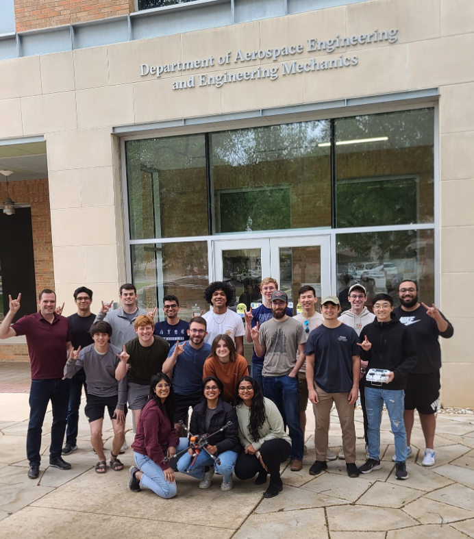 image of students giving longhorn symbol with their hands and smiling