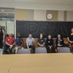 DFSA members posing in front of a blackboard with "DFSA" written in bubble letters.
