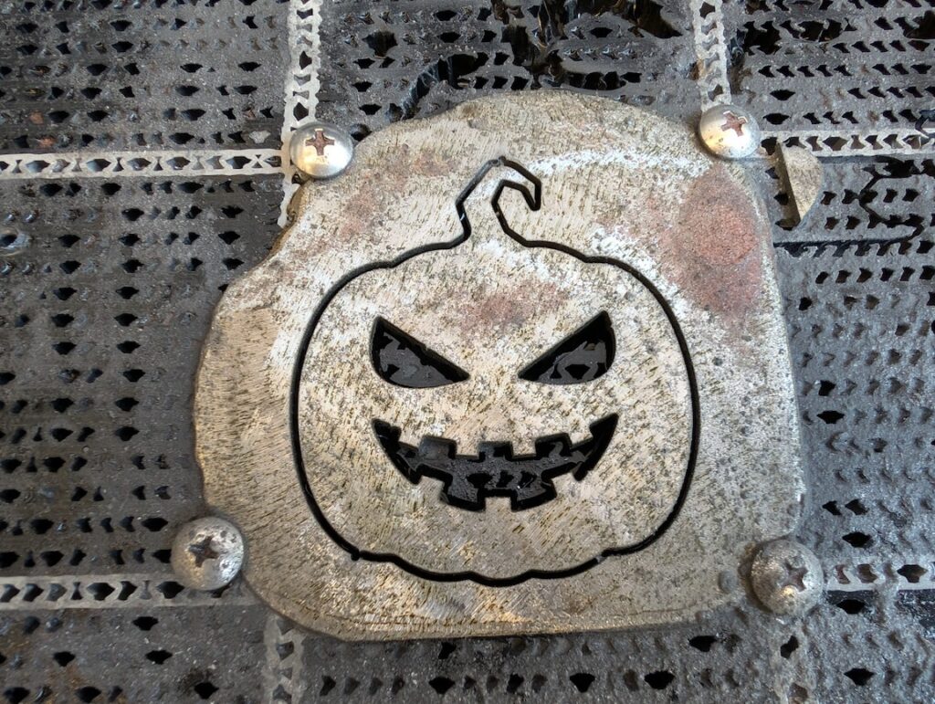 A jackolantern cut into a piece of metal