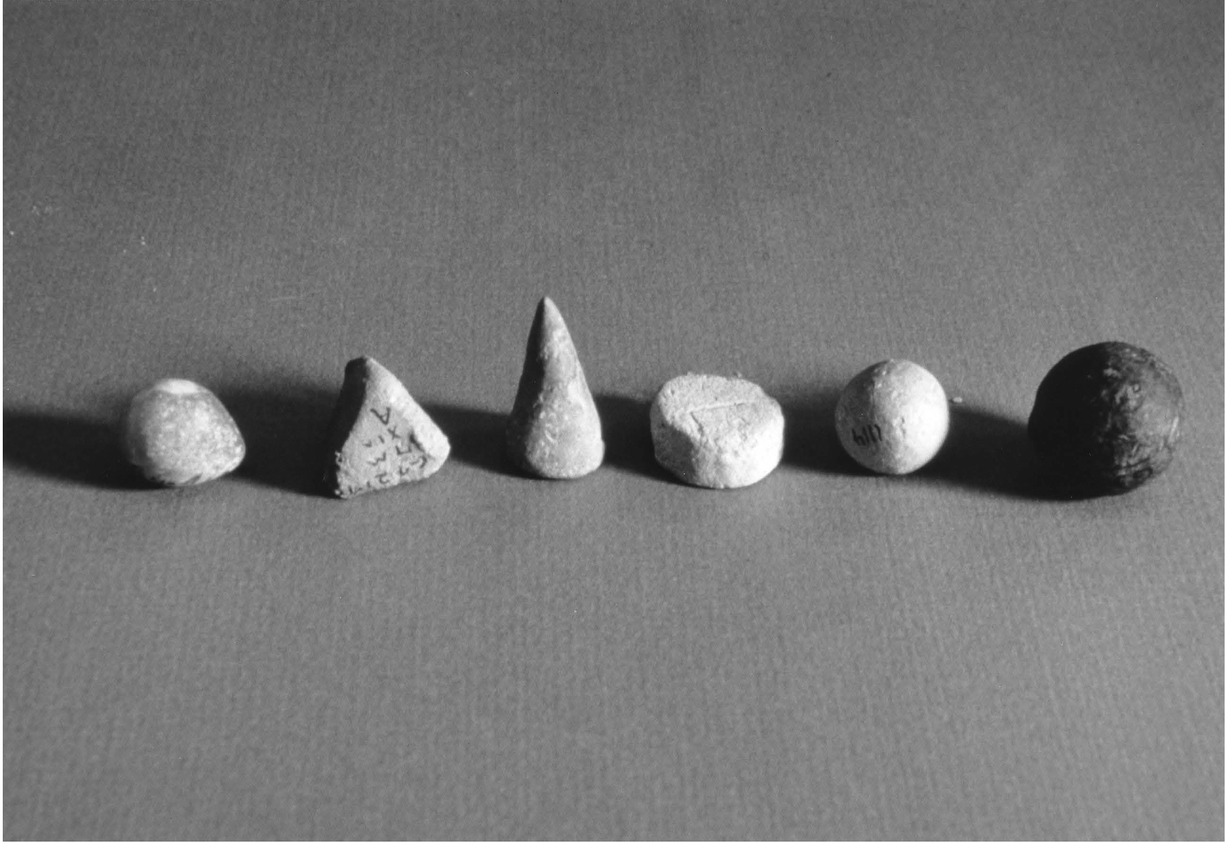 Photograph of 6 tokens in various shapes.