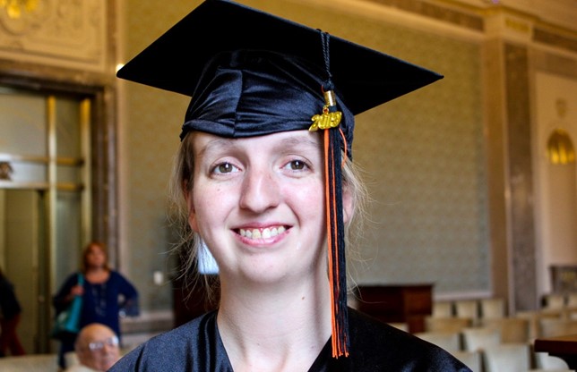 E4Texas Student, female with blonde hair and brown eyes, in graduation cap, smiling.