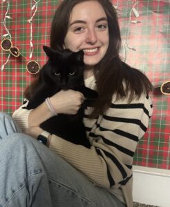 Dana Sheinhaus smiling and holding a cat.