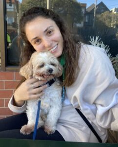 Sophia Khoury smiling with a small dog.