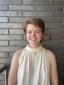 C.D. McAdams smiling and standing in front of a brick wall.