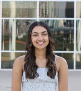 Veena Namboodiri smiling and standing in front of a building