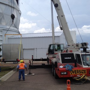 The experts from Crane Services lift the WFC over to the mouth of the loading bay. Then our expert sky track driver (seen earlier moving the FPA into the loading bay) moves it the rest of the way.
