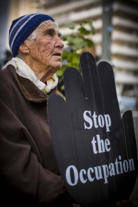 A man holds a sign calling for the end to Israeli occupation of Palestine. Photo Credit: Juliane Kravik Creative Commons Flickr