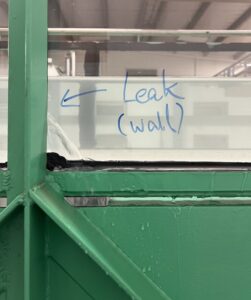 photo of water leaking out the side of one of the glass panels in the flume