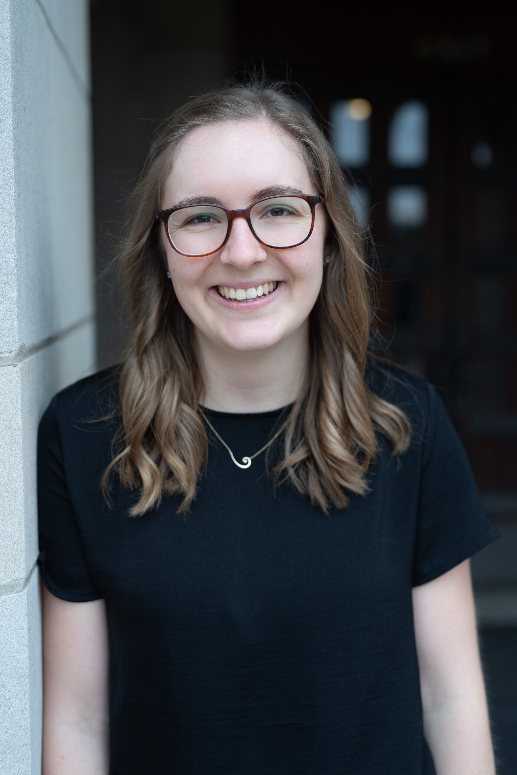 Woman with light brown hair and glasses smiling