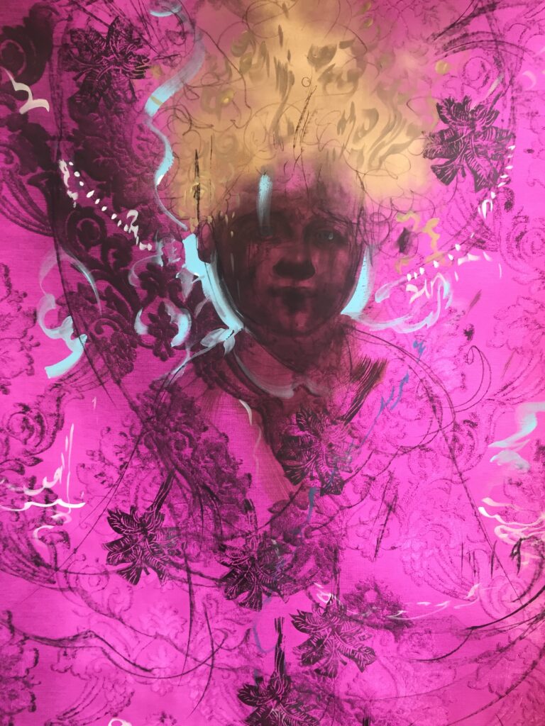 Against a fuchsia background, the dark brown face of a child is in center. Above their head there is gold, and small dark palm trees dot the canvas, as do pale blue squiggles and other dark printed formations.
