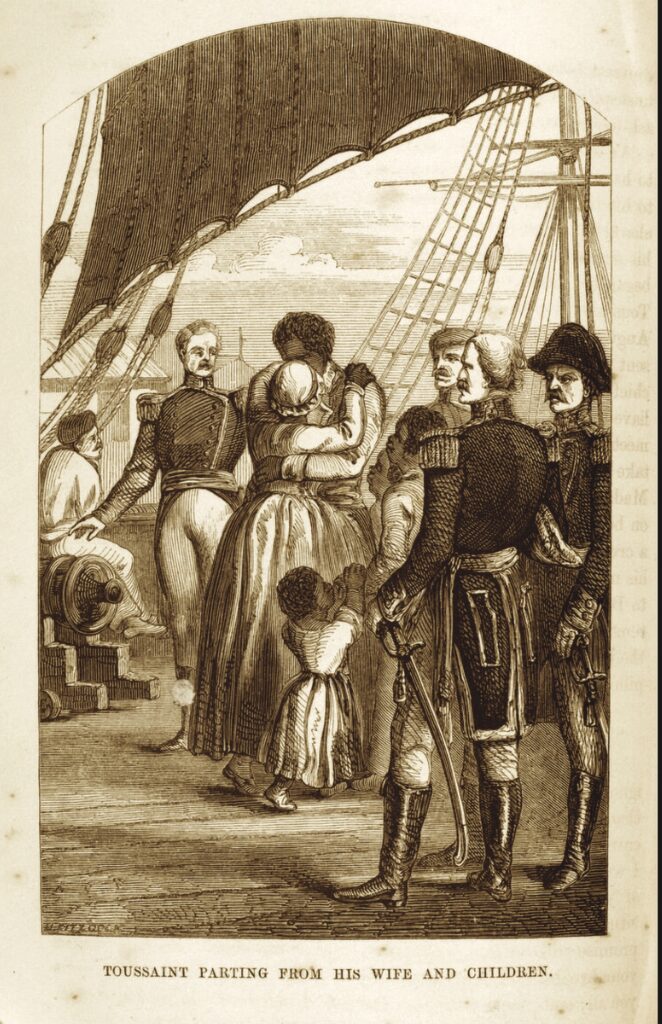 A sepia-toned print from the 1800s shows a scene on board a ship. A Black man hugs a Black woman. Several Black children of different ages stand near them. Other men in the photo are white, in colonial dress. At least one has a scowl on his face; another has his hand on a long sword that is pointed downward. Parts of a sail, the ship's mast, and the sea are visible in the background. The caption reads "Toussaint Parting from his Wife and Children."