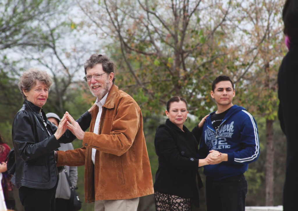 In an outdoor scene, two couples are dancing.
