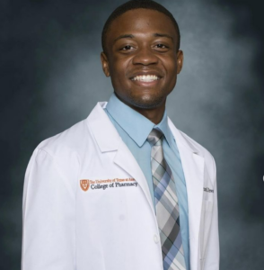 Bruno Onwukwe wearing white coat and smiling in an indoor setting