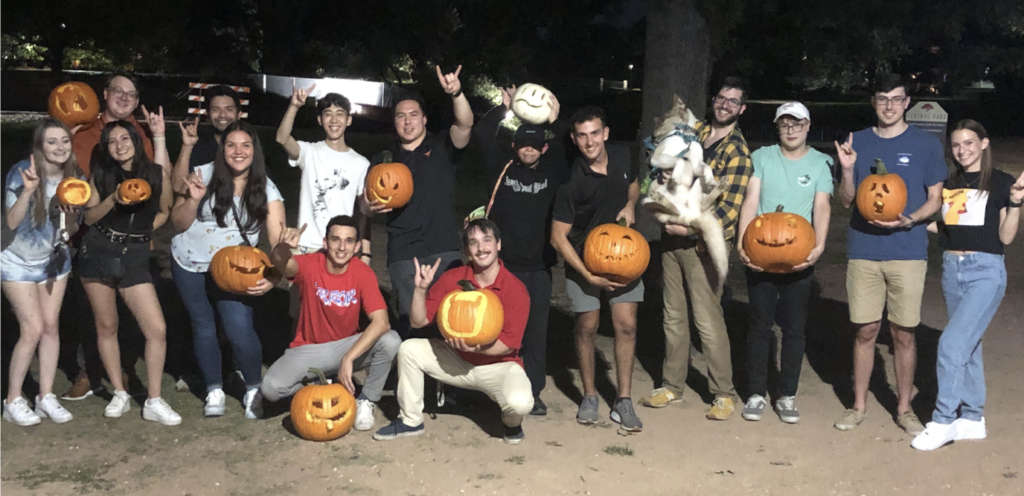 Members standing in a group and holding carved pumpkins