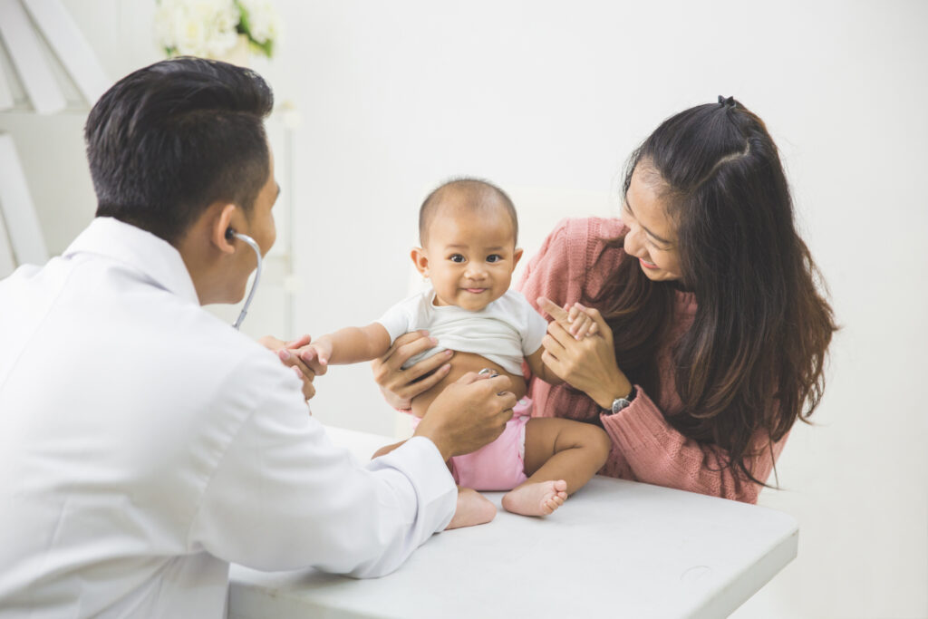 portrait of a baby being checked by a doctor using a stethoscope