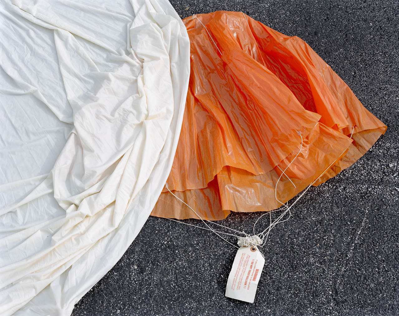 bright orange plastic fabric on ground, partially below white fabric