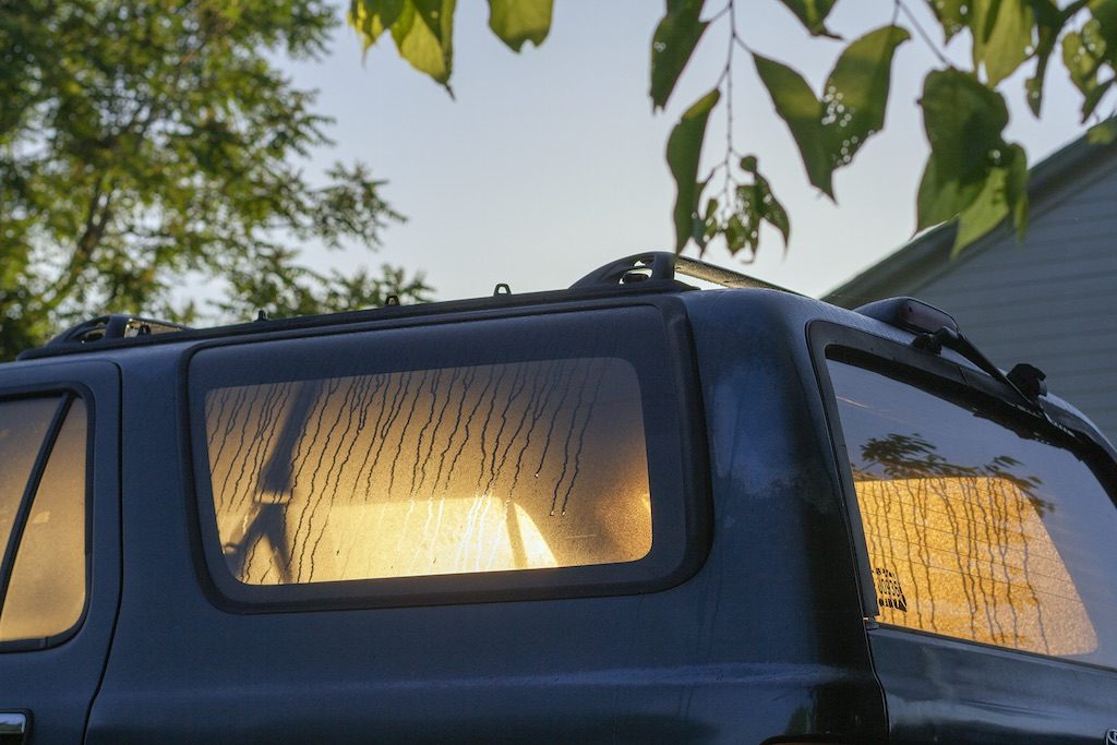 light shining through vehicle windows illuminating dew drips