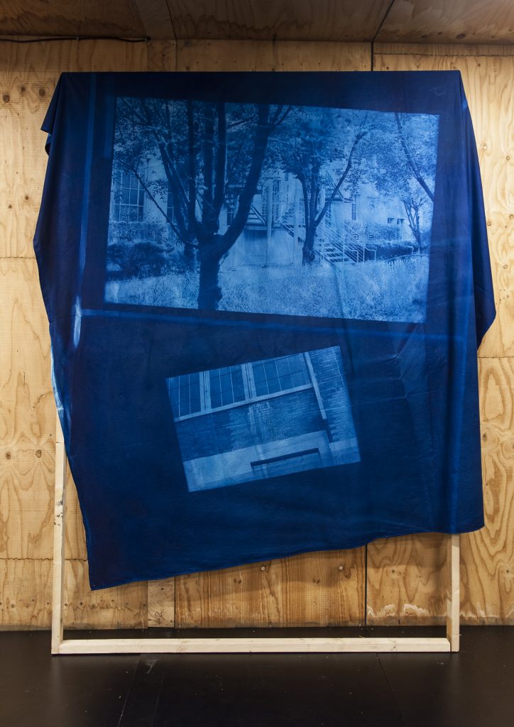 image projections on blue fabric draped over wooden frame