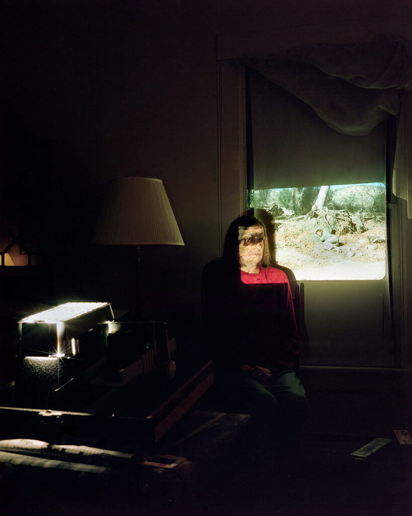 slide projection over woman's face in dark room