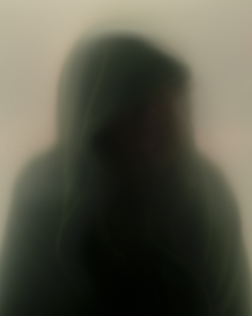 blurry image of what appears to be person in hoody
