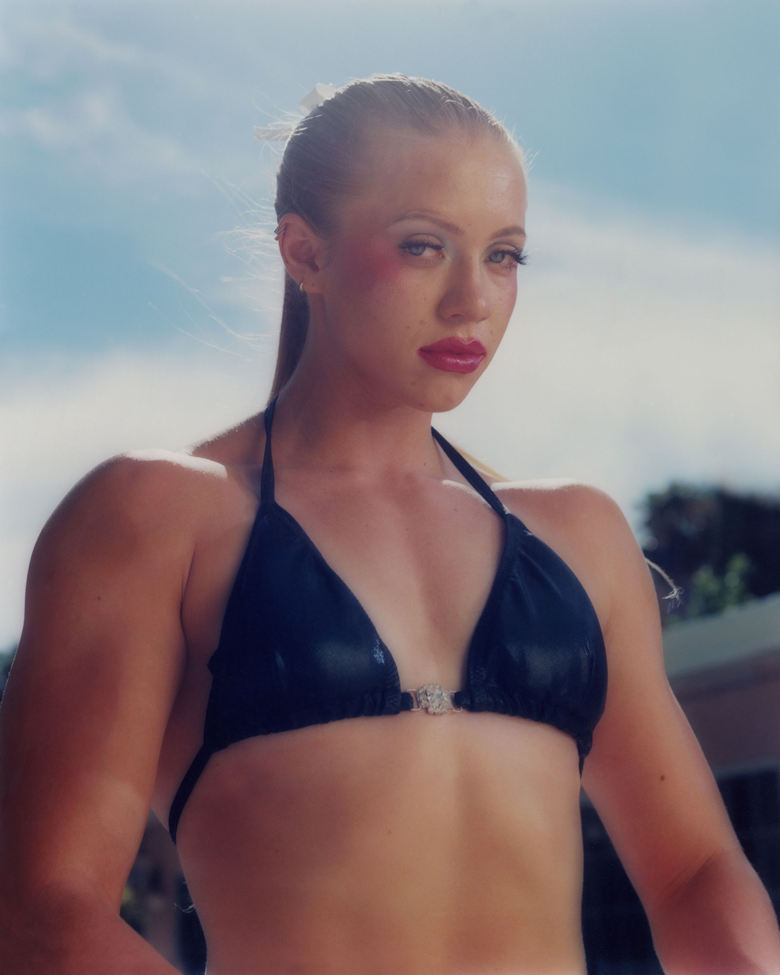 muscular person wearing bikini top looking directly into camera